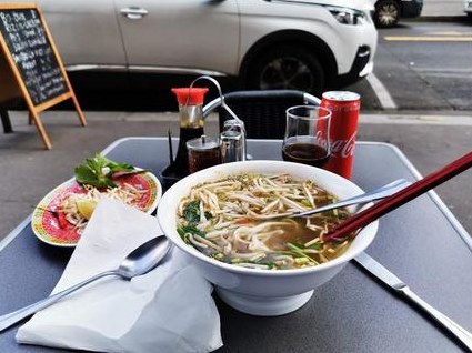 Soupe vietnamienne servie avec herbes fraîches